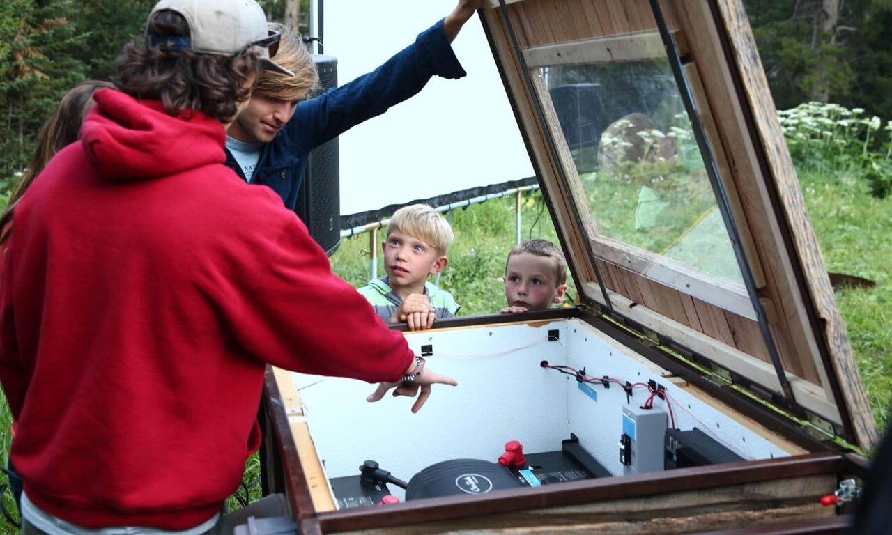 People looking inside the power setup for a traveling film festival