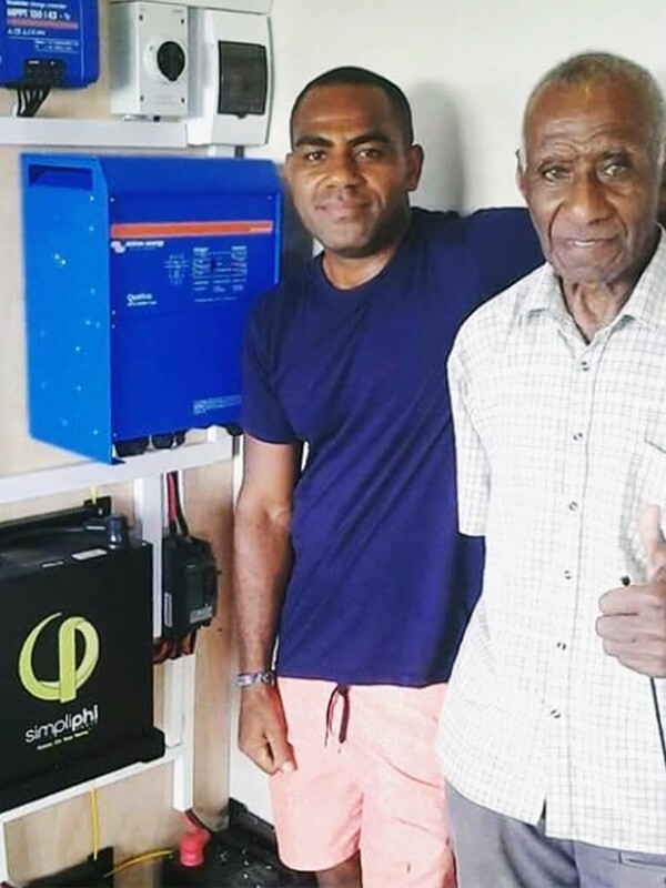 Homeowners in Fiji next to their installed PHI batteries