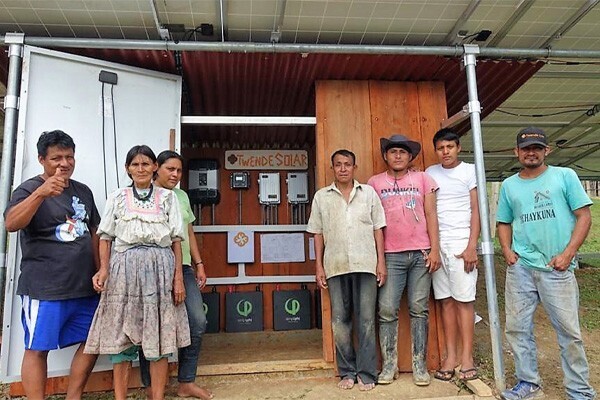 Mushuk Lama residents next to new battery system for their community center