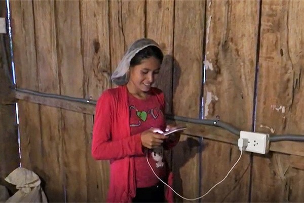 Muhsuk Lama resident using phone powered from new battery system installation