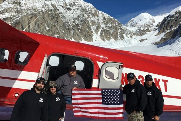 Veterans outside of a plane in the mountains