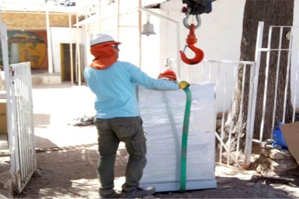 Workers moving solar panels with equipment, installation