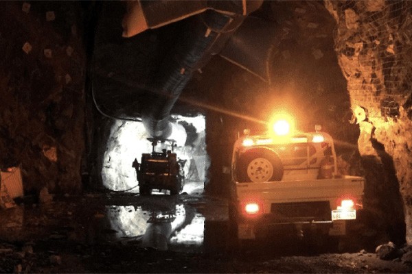 Trucks driving in and illuminating a mine in Australia