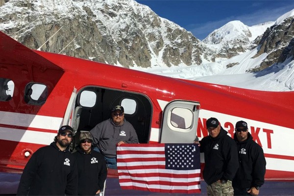 Veterans outside of a plane in the mountains